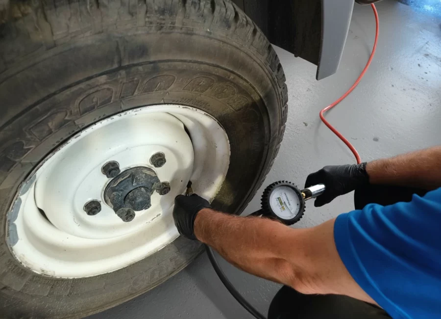 Mechanic performing tire air pressure check in the garage
